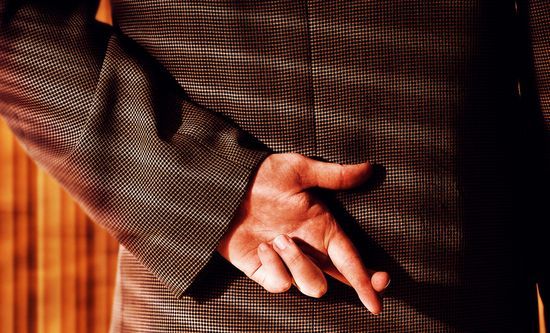 Fotografía de un hombre de negocios que cruza los dedos detrás de su espalda
