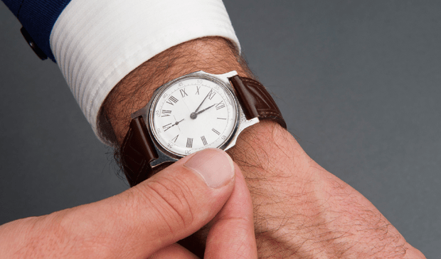 Fotografía de un hombre dando cuerda a su reloj de pulsera